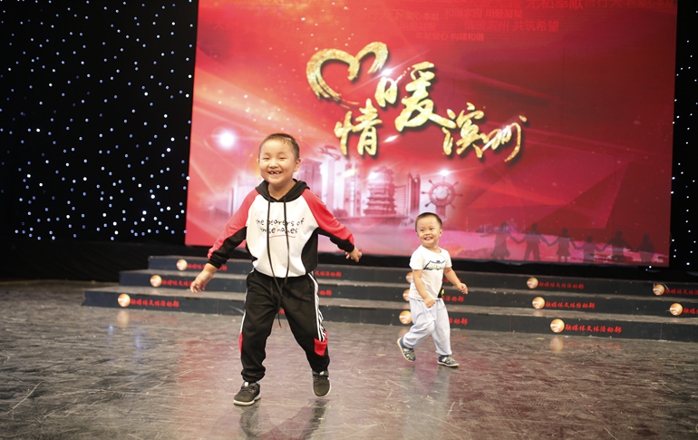 杨熠（左）和李岩四岁的儿子在舞台上嬉戏