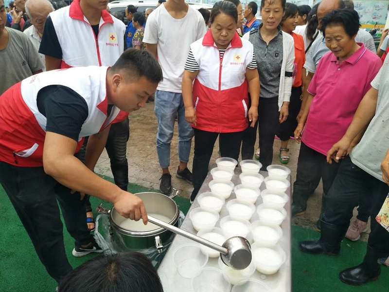 红十字志愿者在安置点为受灾群众分发食品